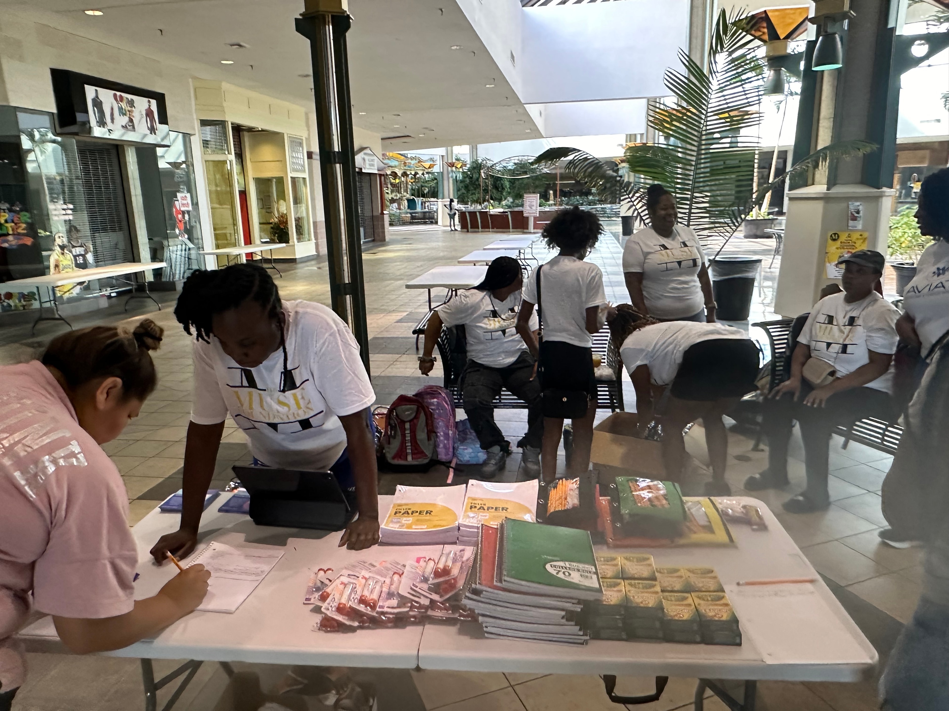 Families registering at the Muse Foundation backpack giveaway table