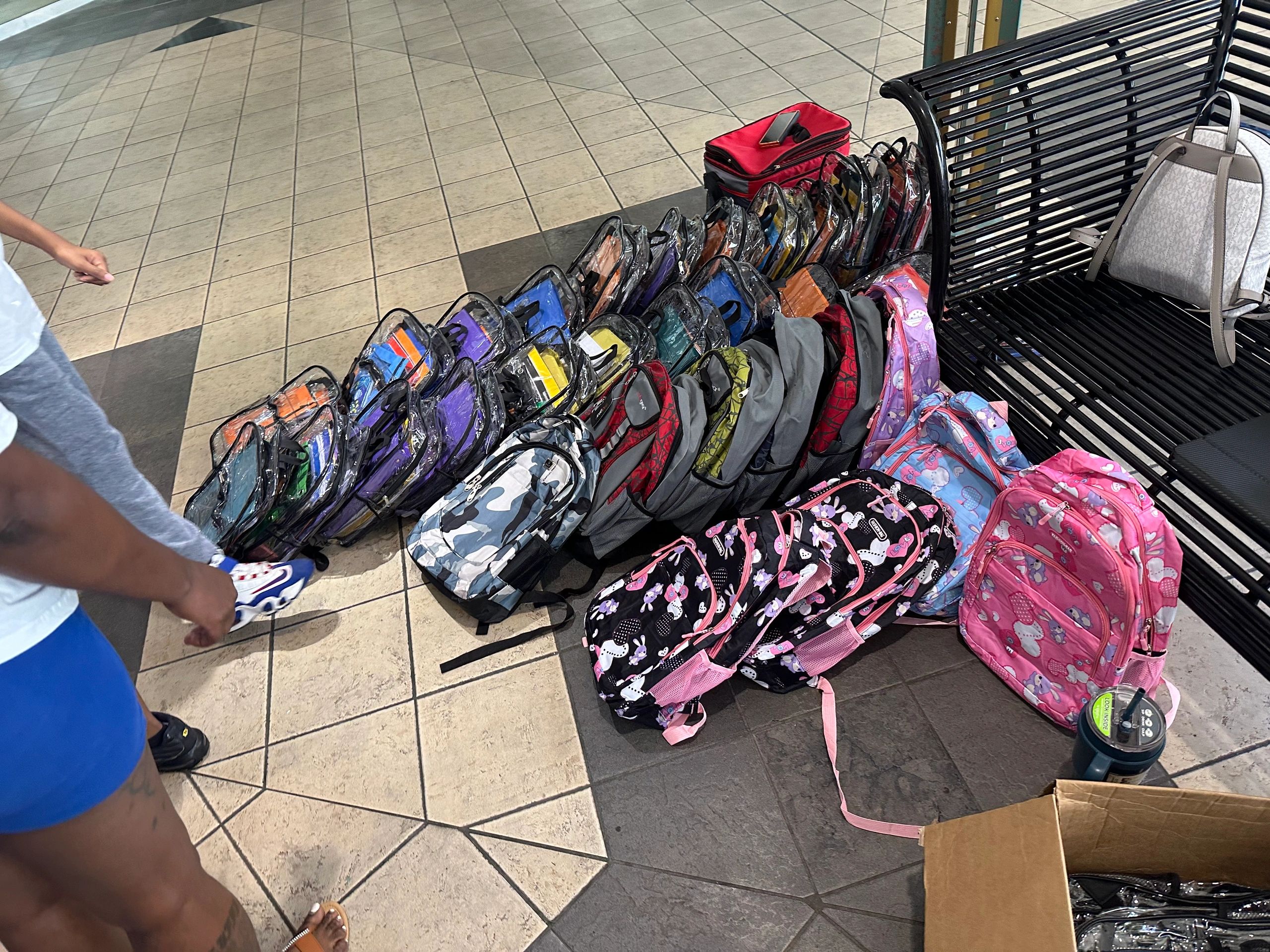 Rows of colorful backpacks filled with school supplies ready for distribution