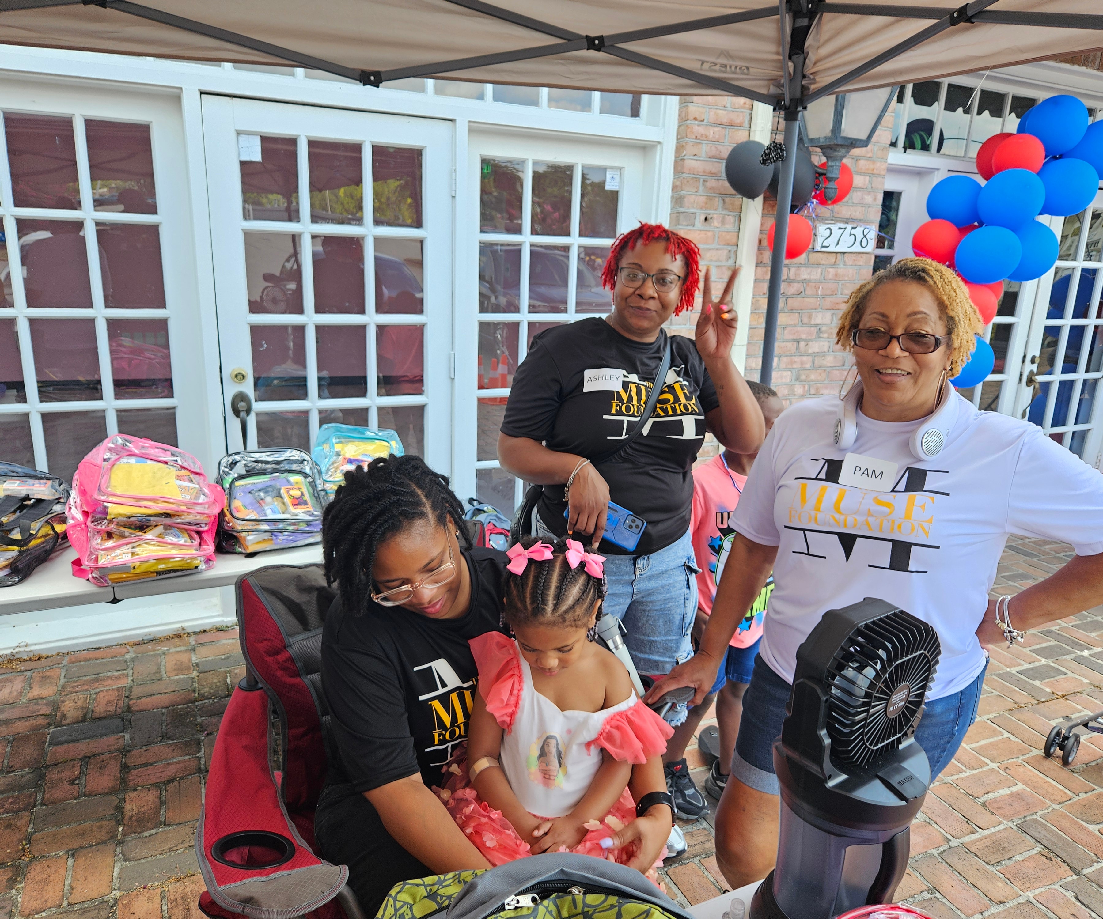 Muse Foundation team members smiling at the backpack giveaway event